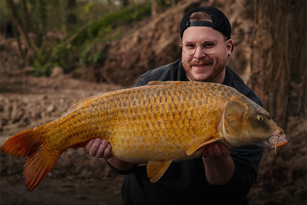 Catch photograph of an angler holding a carp